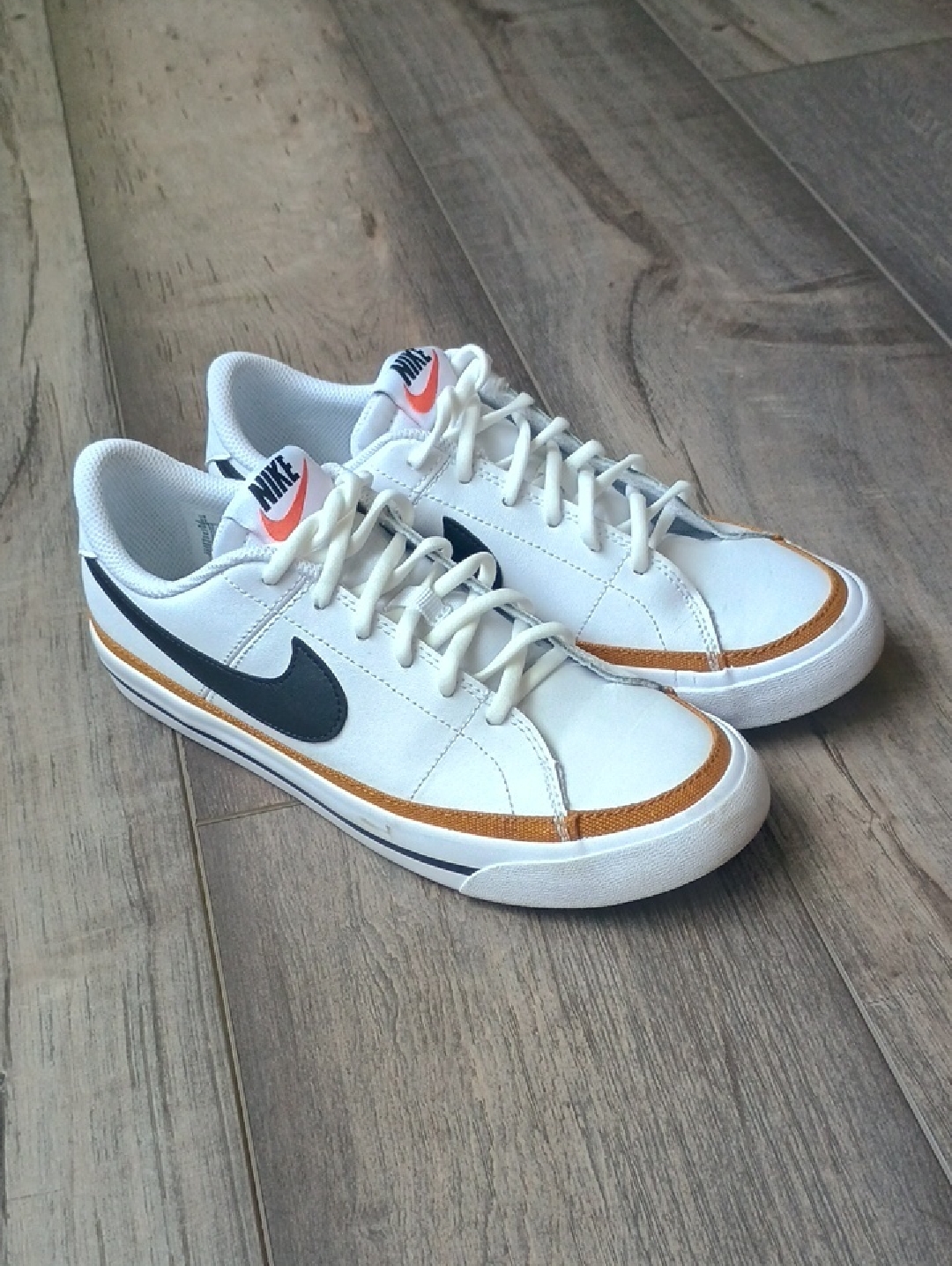Nike White Low-Top Sneakers With Black Swoosh And Gold Accent